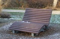 Lonely standing brown bench in winter park Royalty Free Stock Photo