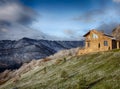 Lonely stone house on the hill on the background of snowy mountains, hdr Royalty Free Stock Photo