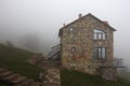 Lonely stone house on the hill in fog, side view Royalty Free Stock Photo