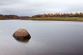 Lonely stone in water in Autumn in Russia. Amazing landscape of far North of Russia