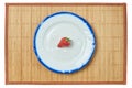 Lonely strawberry on a white plate with a blue rim Royalty Free Stock Photo