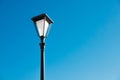 Lonely street lamp on a blue sky background, black and white color, isolated, with space for text, copy space. Royalty Free Stock Photo