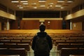 Lonely student in dim university lecture hall Royalty Free Stock Photo