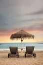 Lonely sun beds and umbrella with view of stunning sunset - Tenerife, Canary Islands.