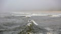 Lonely surfer catching a wave on a cold gloomy day