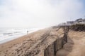 Lonely surfer on a foggy beach Royalty Free Stock Photo