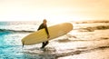 Lonely surfer walking with longboard at sunset in Tenerife - Surfing adventure lifestyle and sport travel concept