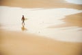 Lonely surfer walks with her board on a beach in Brazil