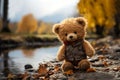 Lonely Teddy bear doll standing alone with blurry autumn forest background,Lost brown bear toy looking sad,International missing