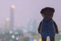 A lonely Teddy Bear looking out from glass window when raining. Royalty Free Stock Photo