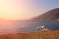 Lonely tent on mountain lake shore. Royalty Free Stock Photo