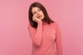 Lonely tired woman in pink sweater leaning head on hand, looking with bored expression, exhausted with overwork