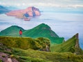 Lonely tourist admiring of sunset on Alaberg cliffs, Faroe Islands, Kingdom of Denmark, Europe. Colorful evening view of Mykines i