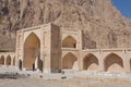 Lonely tourist standing at entrance of stone caravanserai structure, ancient hotel in Iran