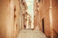 Lonely tourist walking on narrow streets with the old stone houses. Traveling around Malta island