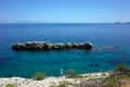 Lonely tourist walking on rocky coast of Aegean sea