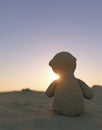 Lonely toy bear facing a sunset 3d render