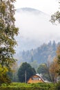 Lonely traditional countryside house near the mountain in misty Royalty Free Stock Photo