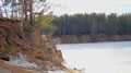 Lonely tree on the slope of the shore of a pond. Frozen water in a pond. Beautiful landscape. Royalty Free Stock Photo