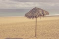 Lonely umbrella on the beach. Vintage parasol, retro photo. Royalty Free Stock Photo