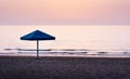 Lonely umbrella on empty beach at dusk Royalty Free Stock Photo