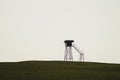 Lonely watch tower. observation post standing alone on the hill. hunting lodge in the field. solitude concept Royalty Free Stock Photo