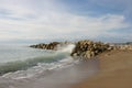 Lonely wave breaks against mass of stones