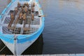 Lonely white-blue wooden boat with oars on the shore of a lake or river Royalty Free Stock Photo