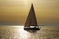 Lonely white sail at infinite ocean on a sunset