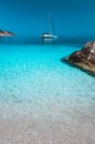 Lonely white sailing catamaran boat drift on calm sea surface. Pure azure clean blue lagoon with shallow water and