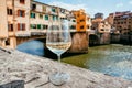 Lonely white wine glass in distance from people, past famous bridge of Florence, Italy. Empty european city