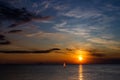 Lonely Wind surfer setting sail towards the dramatic and magnificent scenic sunset at the coast of the mediterranean sea in Royalty Free Stock Photo