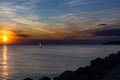 Lonely Wind surfer setting sail towards the dramatic and magnificent scenic sunset at the coast of the mediterranean sea in Royalty Free Stock Photo