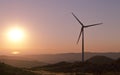 Lonely wind turbine with sun setting on the background Royalty Free Stock Photo