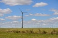 Lonely wind turbine under a cloudy sky and the horizon full wind mills in the countryside of Uruguay Royalty Free Stock Photo