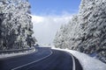 Lonely winding road in a snowy mountain landscape on a sunny winter day. Getaway by car concept Royalty Free Stock Photo