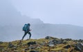 Lonely woman with backpack and trekking poles going by mountain route during Makalu Barun National Park near Tuli Kharka