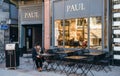 Lonely woman eating croissant and drinking coffee at Paul cafe Royalty Free Stock Photo