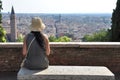 Lonely woman sitting at the bench and looking at Verona town