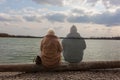 Lonely woman sitting by the lake with ghost of a man sitting by her side Royalty Free Stock Photo