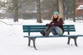 Lonely woman sitting on park bench in winter Royalty Free Stock Photo