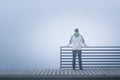 Lonely woman standing alone on the bridge, lost in thought on a foggy day Royalty Free Stock Photo