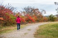 Lonely woman strolling along a gravel path on a cloudy autumn day Royalty Free Stock Photo