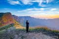 Lonely woman on top of the mountain with sunrise background