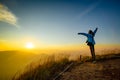 Lonely woman on top of the mountain with sunrise background