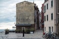 Lonely woman walking her dog in the cold, old streets of Rovinj, beautiful adriatic coastal town in region of Istria