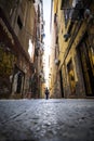 Lonely woman walking on the narrow street of Naples, Italy