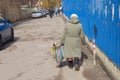 Lonely woman walks on a street carrying handbag with bunch of flower