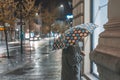 Lonely woman windowshopping alone at night during rain. Rainy stroll through the city Royalty Free Stock Photo