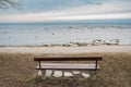 Lonely wooden bench on the autumn sea with cloudy sky Royalty Free Stock Photo